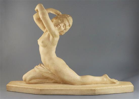 Lucien Alliot. An Art Deco carved stone figure of a naked female dancer, length 28in. height 18in.